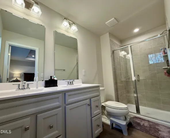 a bathroom with a double vanity sink toilet and shower