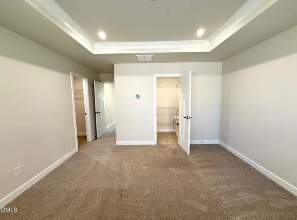 an empty room with closet and a bathroom