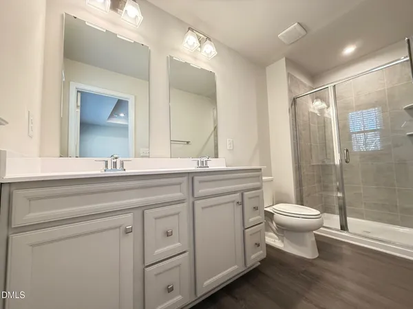 a bathroom with a double vanity sink toilet and shower