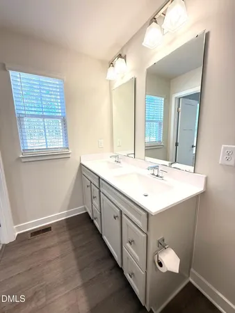 a bathroom with a double vanity sink and mirror with window
