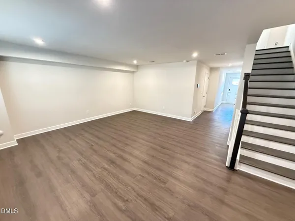 a view of an empty room with wooden floor