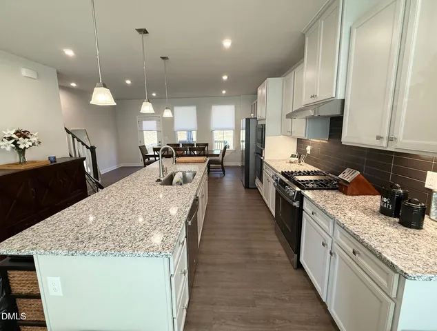 a large kitchen with kitchen island a stove a sink a refrigerator and a counter space