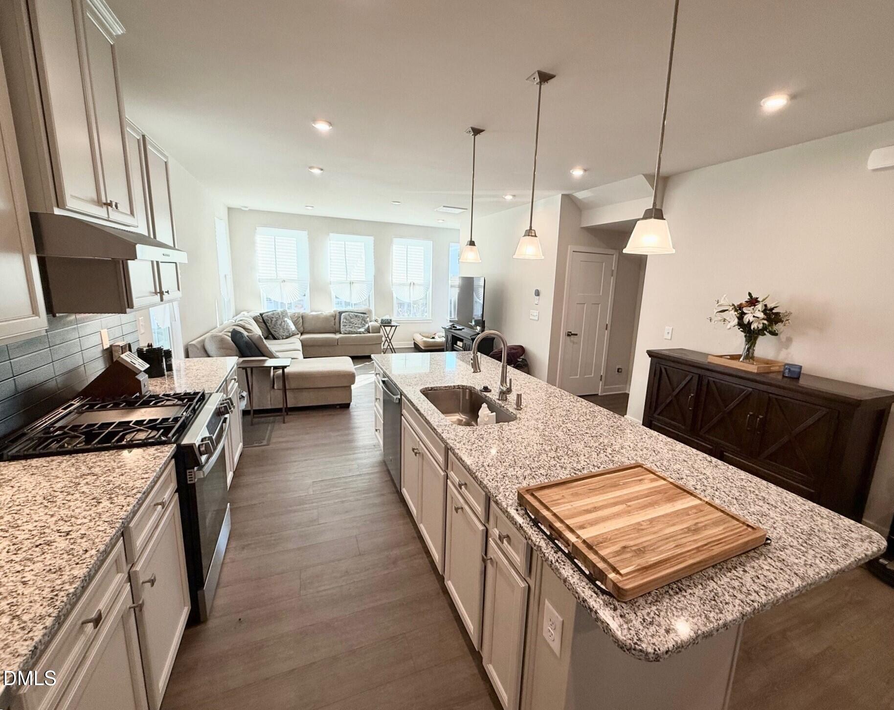 1362 Chowan Avenue Durham, NC 27713 - Photo 7 of 27 a large kitchen with kitchen island a stove a sink a refrigerator a stove a dining table and chairs with wooden floor