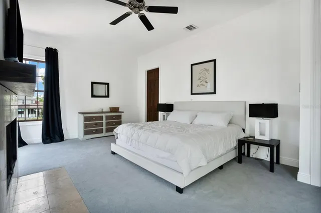 a spacious bedroom with a bed and a tv