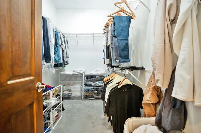 a view of walk in closet with clothes and shoes