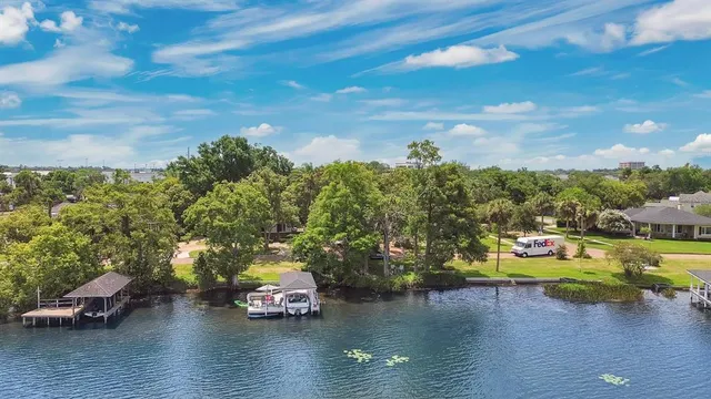 an aerial view of a house with a yard and lake view in back