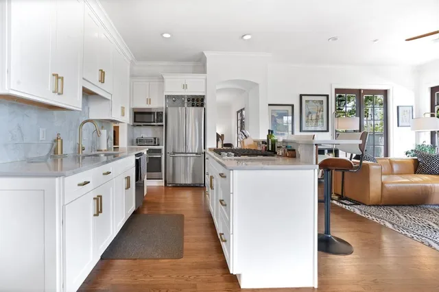a kitchen with stainless steel appliances kitchen island granite countertop a refrigerator and a stove top oven