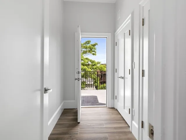 a view of a hallway with wooden floor and stairs