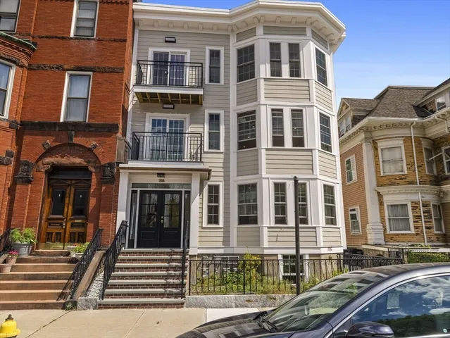 a front view of a residential apartment building with a yard