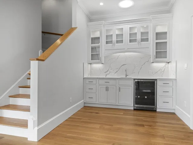 a view of an empty room with wooden floor and cabinet