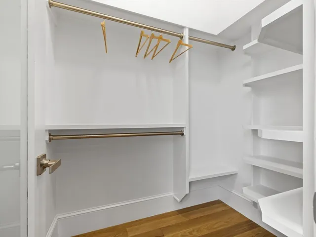 a view of walk in closet with empty racks