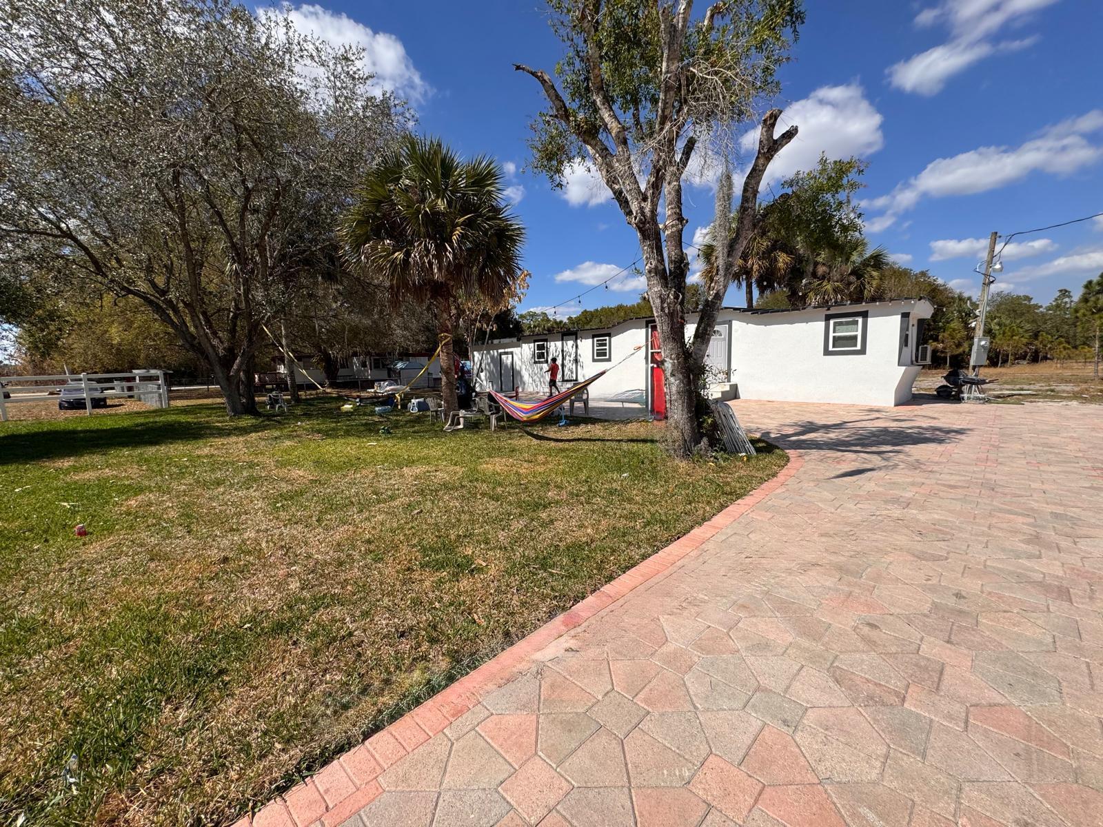 357 Hunting Club Avenue Clewiston, FL 33440 - Photo 25 of 37 a view of a tree in front of a house with a large tree