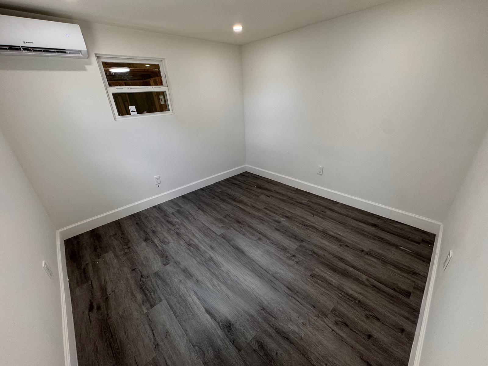 357 Hunting Club Avenue Clewiston, FL 33440 - Photo 9 of 37 a view of a room with wooden floor and a window