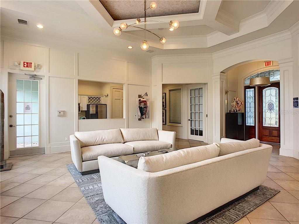 12824 Madison Pointe Circle, Unit 103 Orlando, FL 32821 - Photo 15 of 27 a living room with furniture and a chandelier