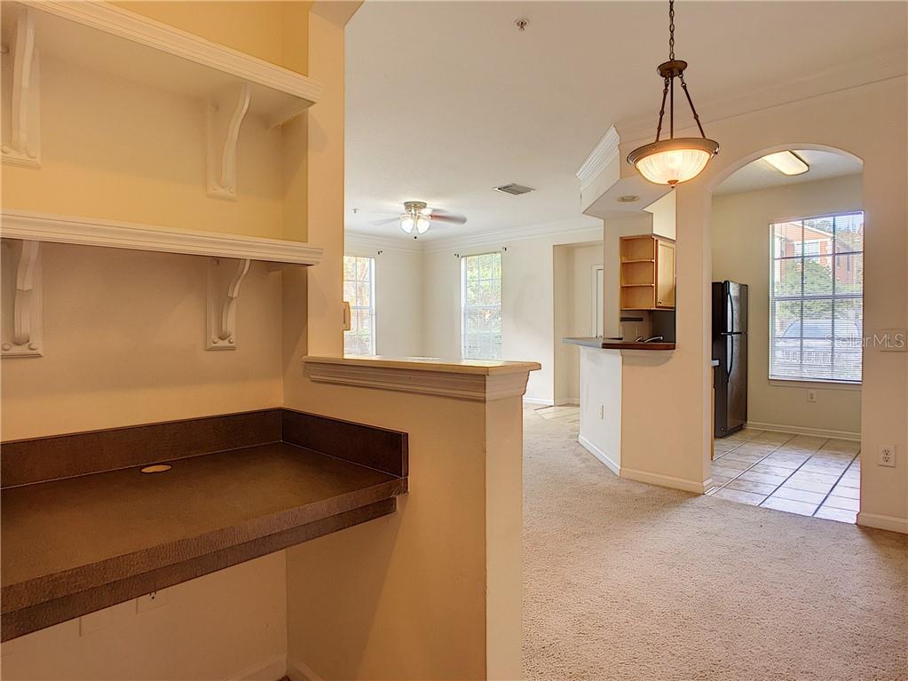 12824 Madison Pointe Circle, Unit 103 Orlando, FL 32821 - Photo 9 of 27 a kitchen with a refrigerator and a sink