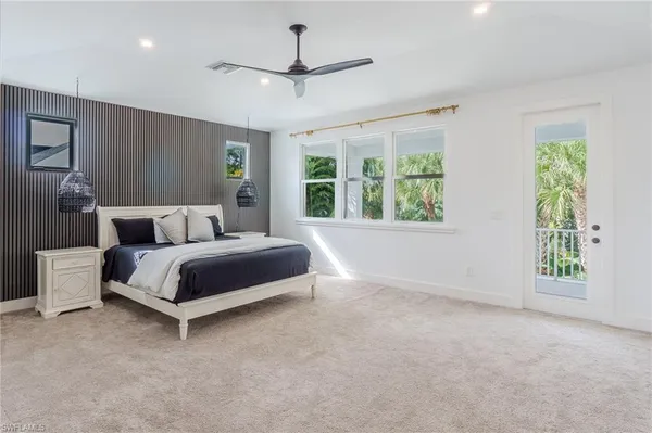 a bedroom with a large bed chandelier and a window