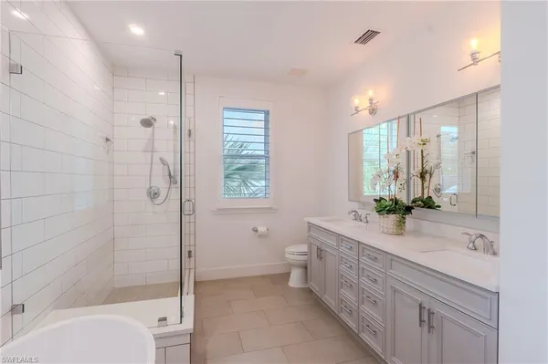 a bathroom with a double vanity sink toilet and shower