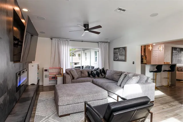 a living room with furniture a flat screen tv and a fireplace