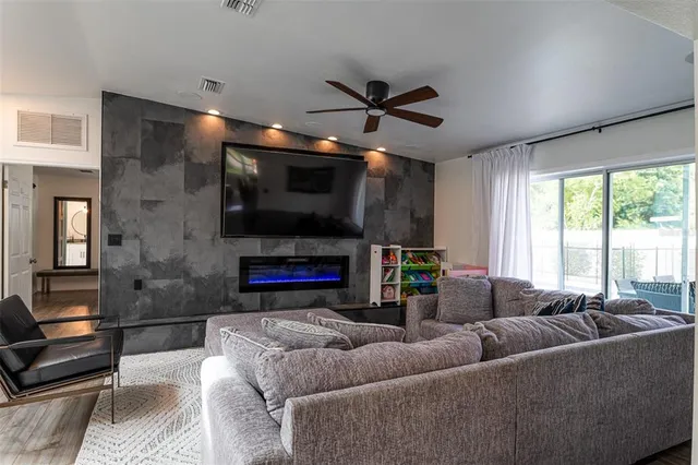 a living room with furniture a flat screen tv and a window