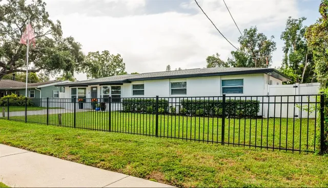 a view of a house with a yard and fence