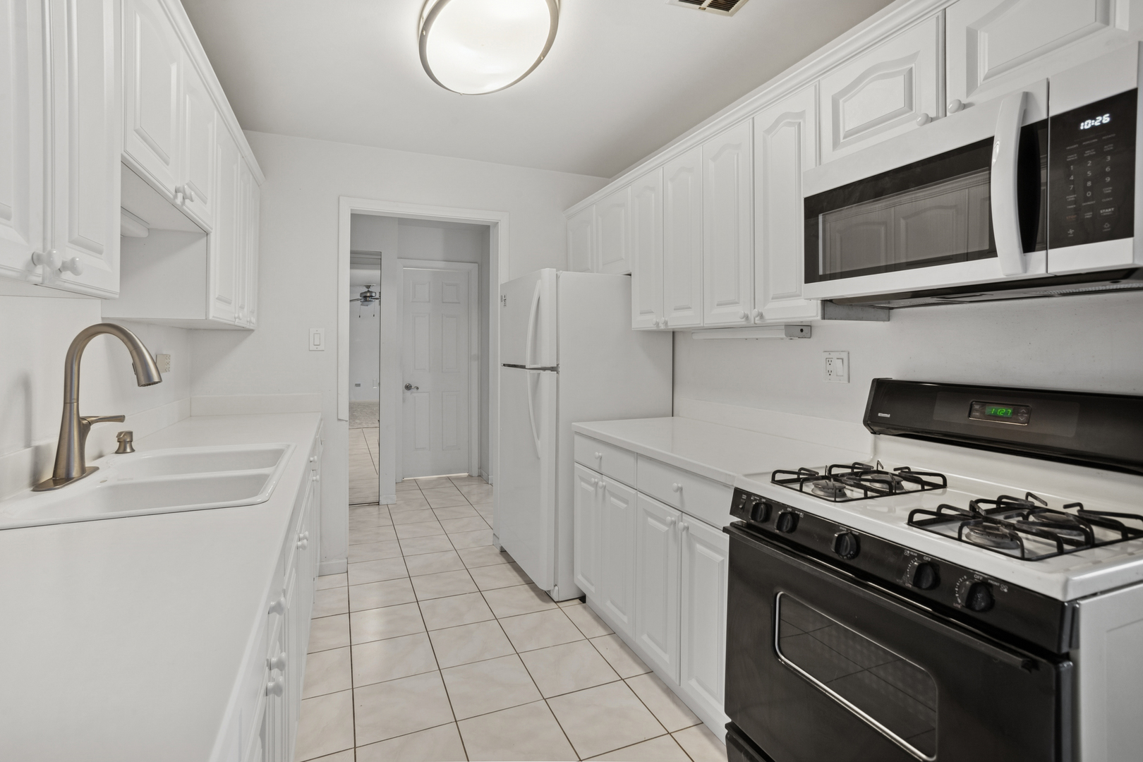 8905 Knight Avenue, Unit 211 Des Plaines, IL 60016 - Photo 13 of 24 a kitchen with stainless steel appliances a sink a stove a microwave and cabinets