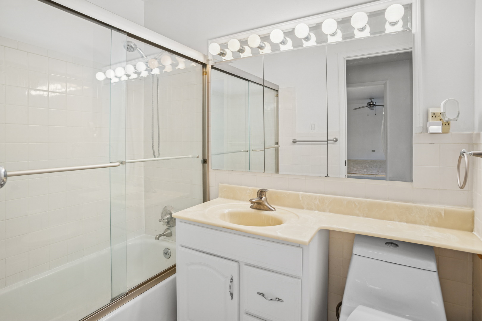 8905 Knight Avenue, Unit 211 Des Plaines, IL 60016 - Photo 21 of 24 a bathroom with a sink mirror and a shower