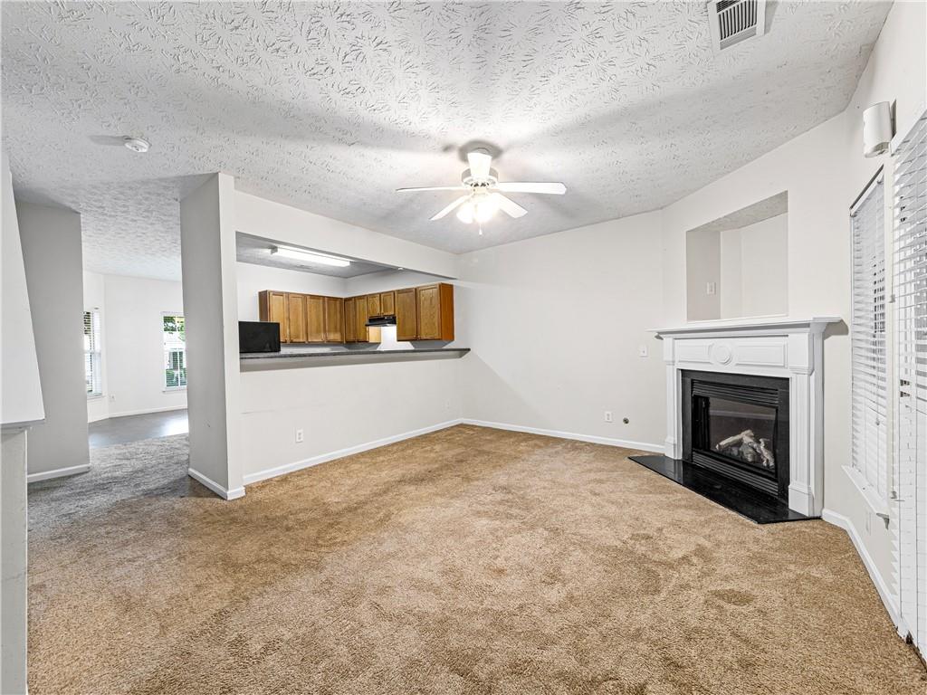 2523 Walden Lake Drive Decatur, GA 30035 - Photo 10 of 19 a view of empty room with a kitchen and fireplace