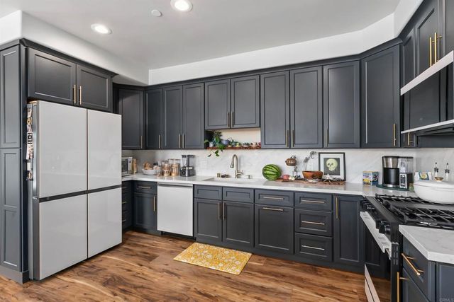 a kitchen with granite countertop wooden cabinets and stainless steel appliances