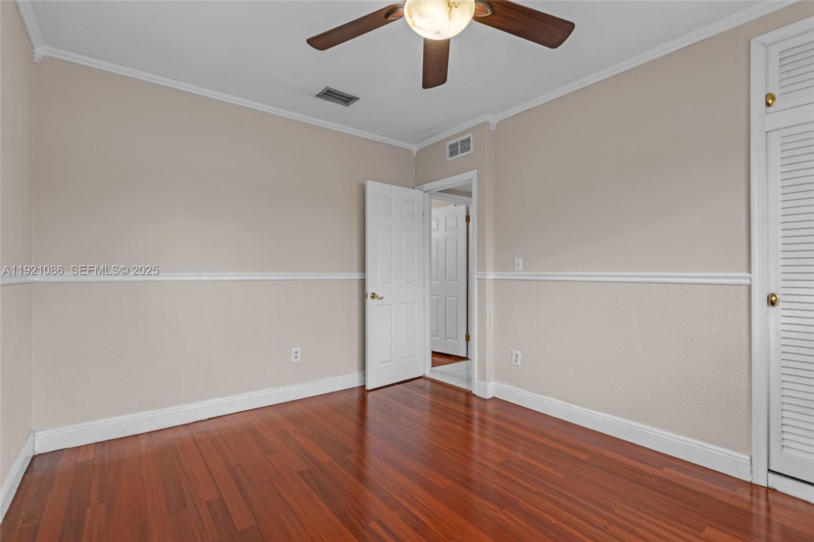 9400 Southwest 193rd Drive, Unit 9400 Cutler Bay, FL 33157 - Photo 11 of 42 an empty room with wooden floor and windows