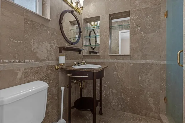 a bathroom with a sink a toilet and a mirror