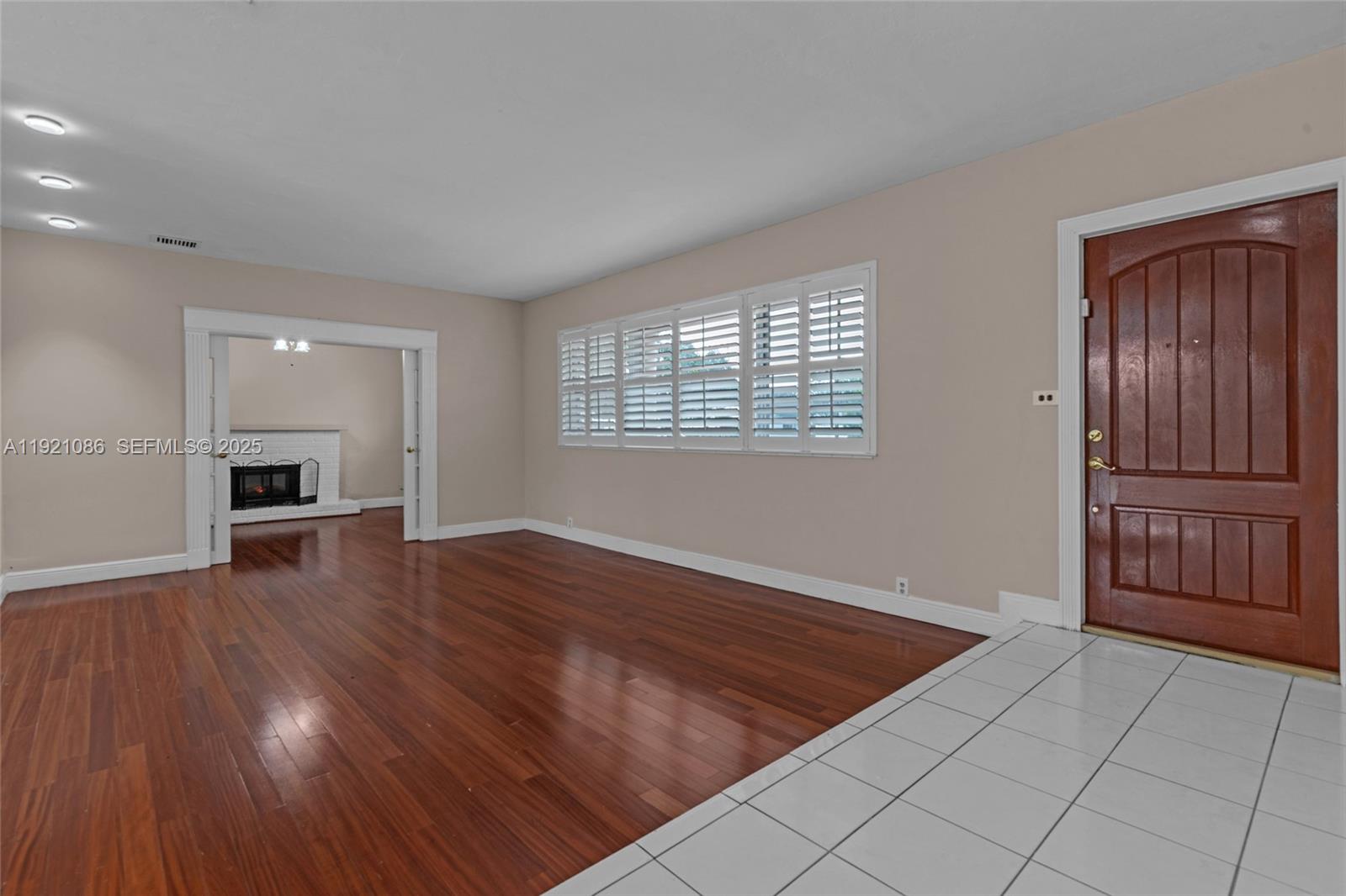 9400 Southwest 193rd Drive, Unit 9400 Cutler Bay, FL 33157 - Photo 20 of 42 a view of an empty room with wooden floor and a window