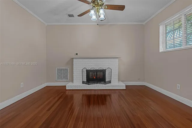 wooden floor fireplace and window in an empty room