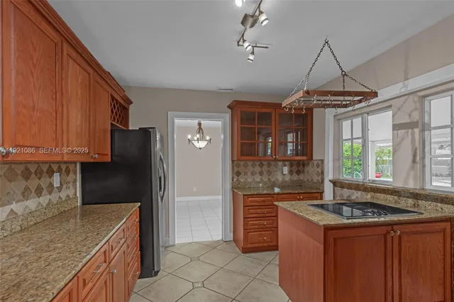 a kitchen with granite countertop a sink stove and refrigerator