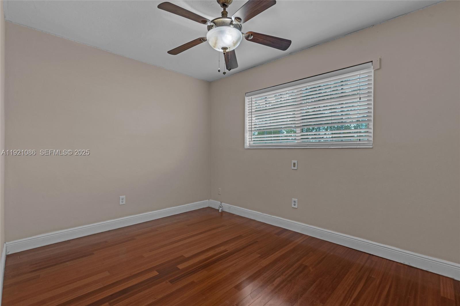 9400 Southwest 193rd Drive, Unit 9400 Cutler Bay, FL 33157 - Photo 8 of 42 a view of an empty room with wooden floor and a window