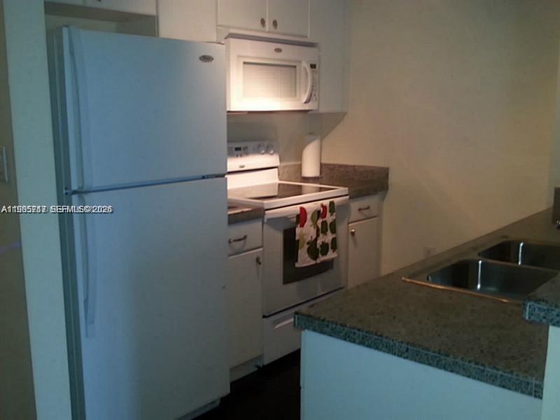 2740 Southwest 28th Terrace, Unit 503 Miami, FL 33133 - Photo 11 of 19 a kitchen with a stove and a refrigerator