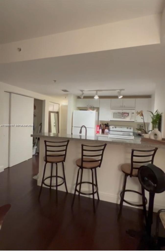 2740 Southwest 28th Terrace, Unit 503 Miami, FL 33133 - Photo 19 of 19 a outdoor kitchen with a table chairs and wooden floor