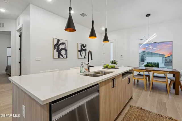 a kitchen with a sink a stove and chairs