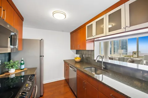 a kitchen with stainless steel appliances granite countertop a sink stove and cabinets