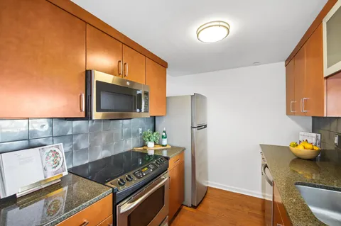 a kitchen with stainless steel appliances granite countertop a stove a sink and a microwave