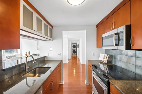 a kitchen with granite countertop a sink and a stove top oven