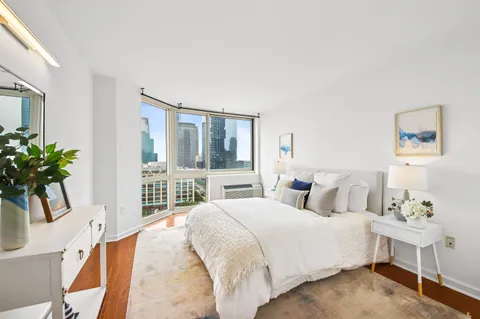 a bedroom with a large bed and a potted plant