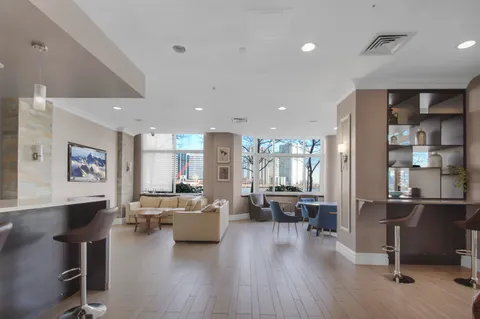 a living room with furniture kitchen view and a large window