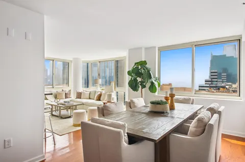 a dining room with furniture and a large window