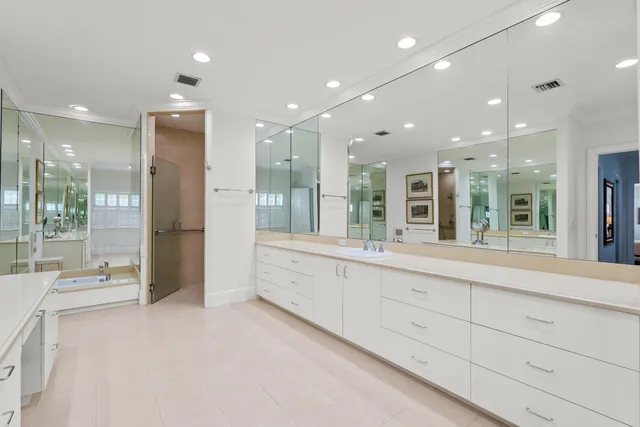 a large bathroom with a large mirror vanity and shower