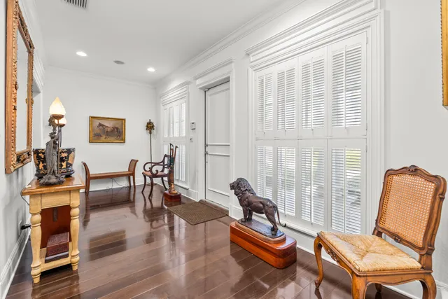 a living room with furniture a wooden floor and next to a window