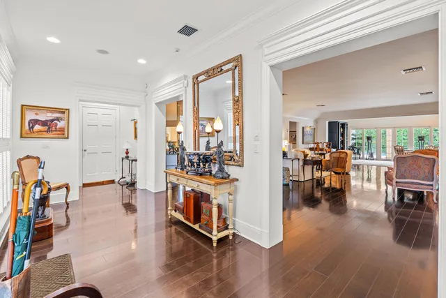 a living room with furniture and a dining table with wooden floor