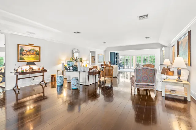 a living room with lots of furniture wooden floor and a large window
