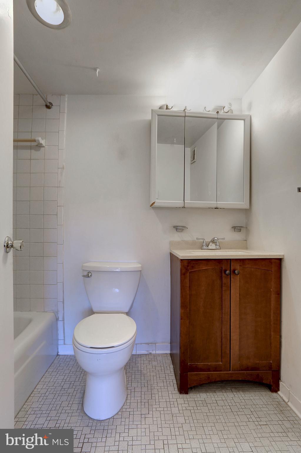 8830 Piney Branch Road, Unit 208 Silver Spring, MD 20903 - Photo 15 of 25 a bathroom with a toilet a sink and mirror