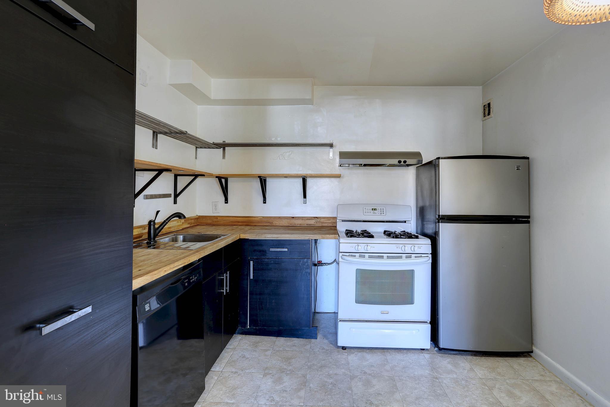 8830 Piney Branch Road, Unit 208 Silver Spring, MD 20903 - Photo 6 of 25 a kitchen with a stove and a refrigerator