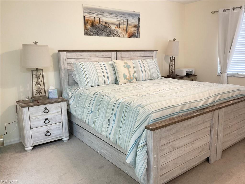 7380 St Ives Way, Unit 1204 Naples, FL 34104 - Photo 16 of 33 a bedroom with a bed and a night stand